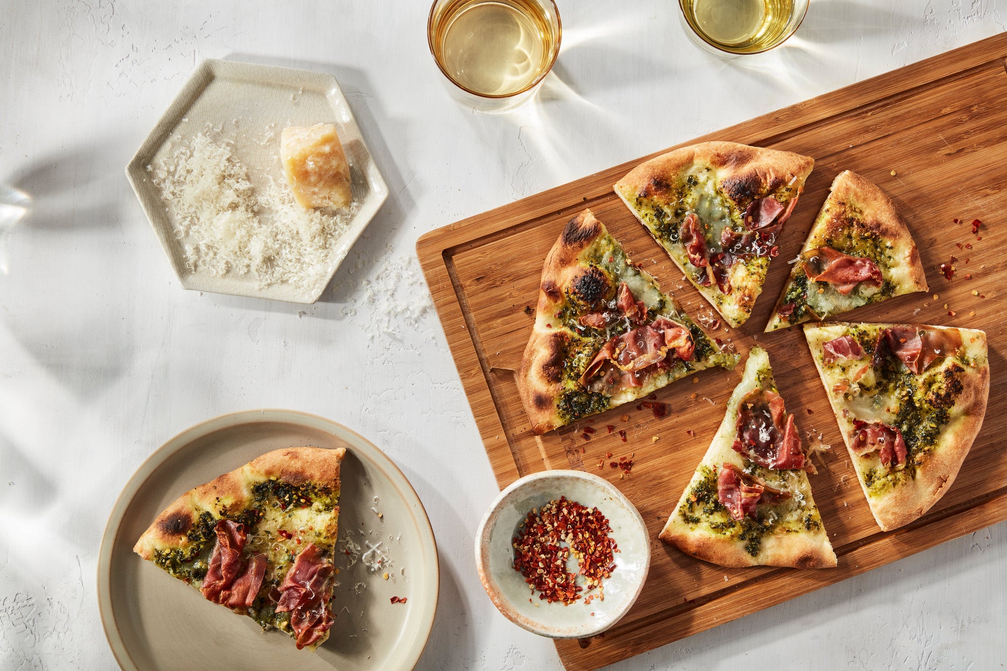 Pizza de pesto, rúcula y pistacho, prosciutto y burrata